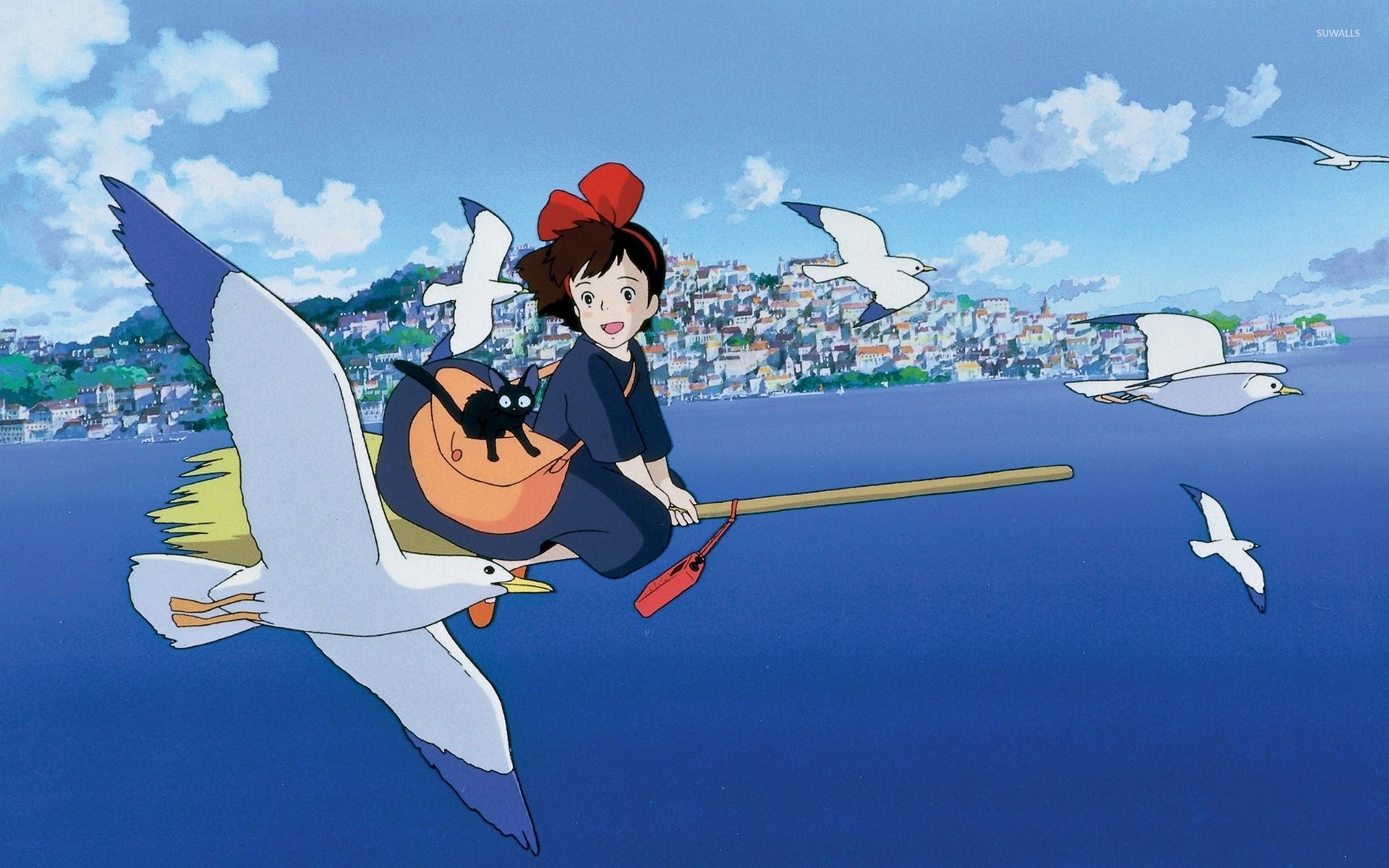 Young witch in a billowy black dress and red hair bow joyfully riding her broom through a seaside sky, accompanied by gliding seagulls.